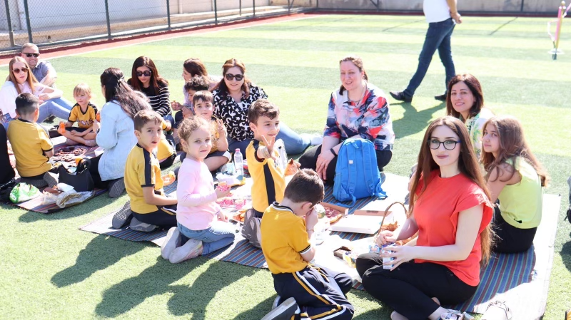 PYP1 students enjoying a picnic with their parents and teachers